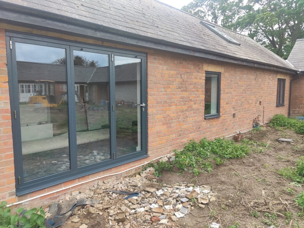 grey bifold doors replacing an old set of doors in a bungalow